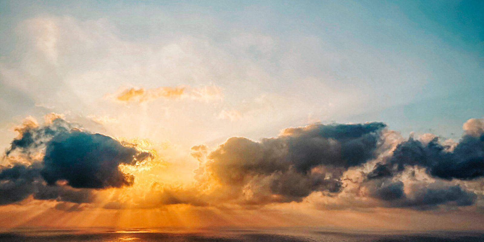 Der Sonnenuntergang über dem Meer mit dunklen Wolken, die die Sonne teilweise verdecken, ruft eine Zen-artige Ruhe hervor. Sonnenstrahlen brechen durch und werfen einen warmen Schein auf das Wasser. Der Himmel wechselt von Blau zu Orange und verwandelt diese Szene in eine innere Reise dramatischer Reflexion und ruhiger Achtsamkeit.